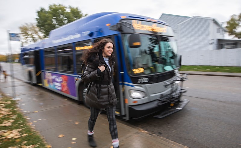 Student walking beside an ETS bus