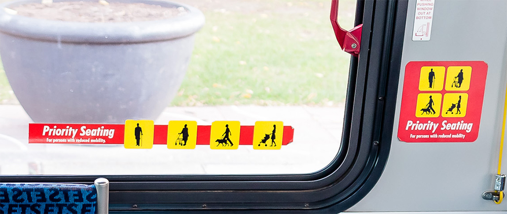 Priority seating stickers on window and the wall of an ETS bus