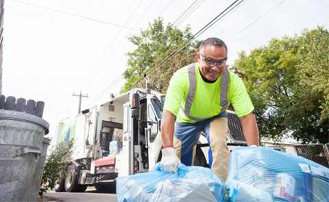 Waste Collector picking up blue recycling bags