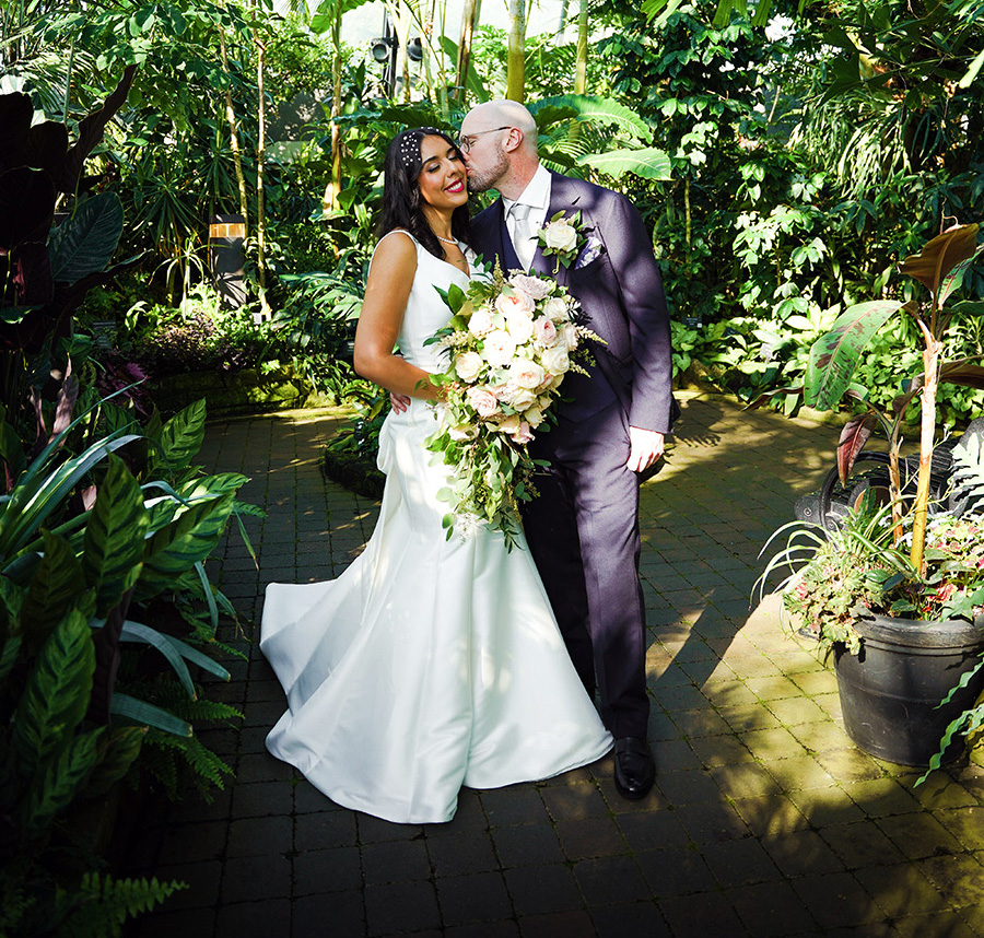 Wedding couple surrounded by plants