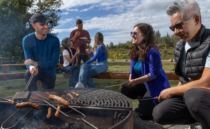 A group of people surrounding a campfire.