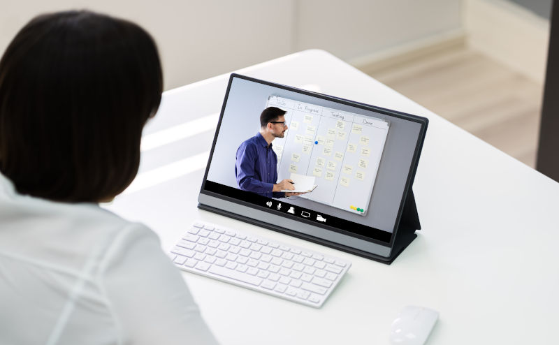 person watching meeting on laptop