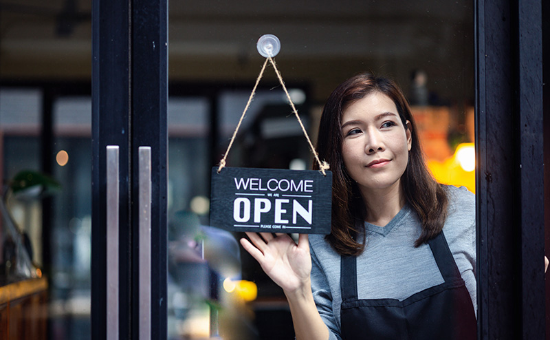 Business owner flips an open sign