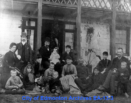 Photograph of 3 families in front of the Big House at Fort Edmonton in 1884.