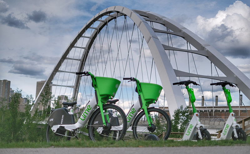 Lime e-scooters and e-bikes parked beside the Walterdale Bridge