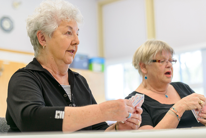 2 senior persons playing cards