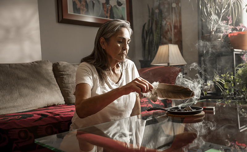 woman sitting on couch smudging