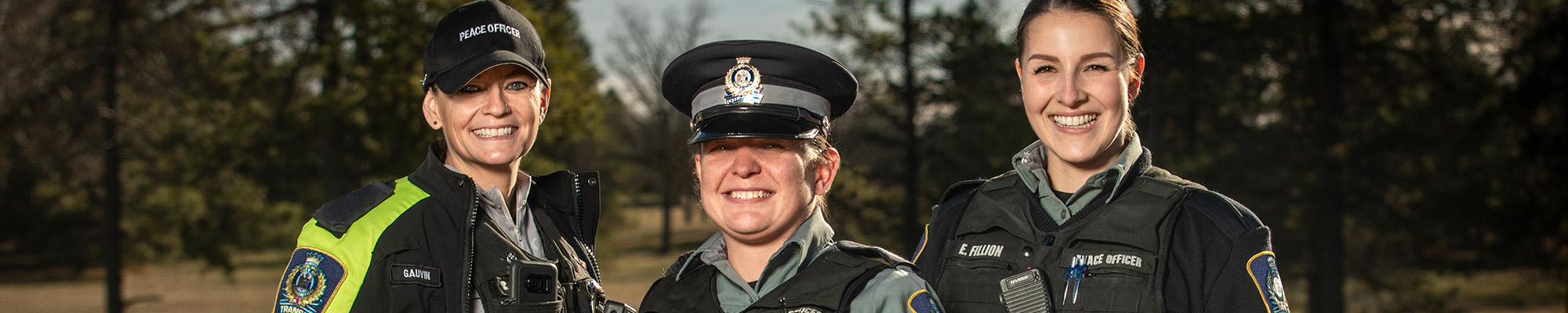 three peace officers standing smiling