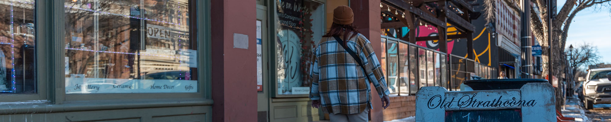 Person walking by shops on Whyte Avenue