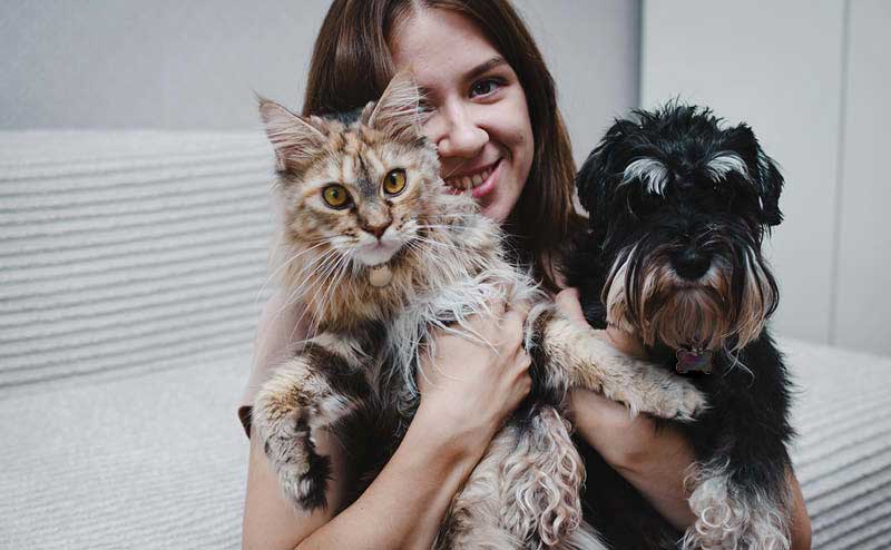 Person holding a dog and a cat