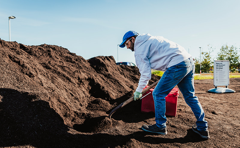 man shoveling compost