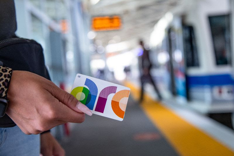 Person holding an Arc card on LRT platform