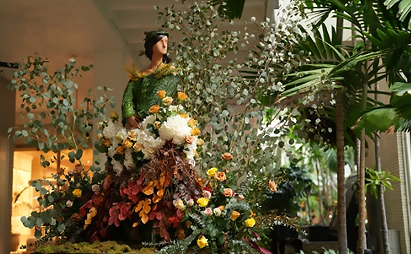 Mannequin surrounded by plants.