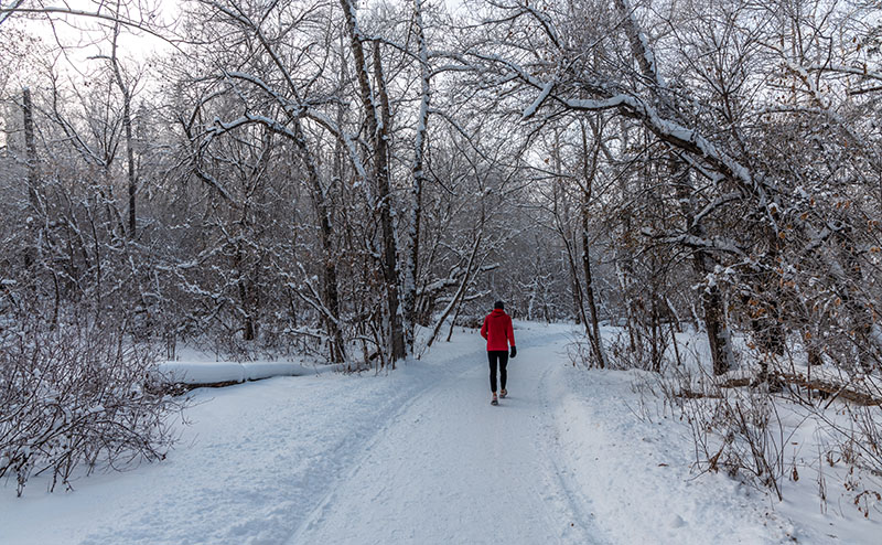 man walking on snowy trail