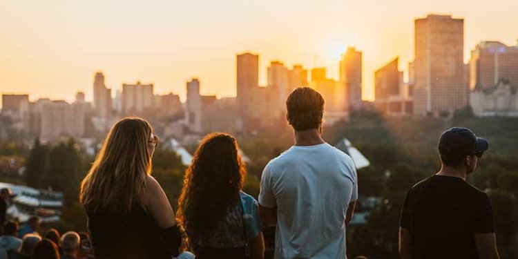 people standing looking out at dark skyline