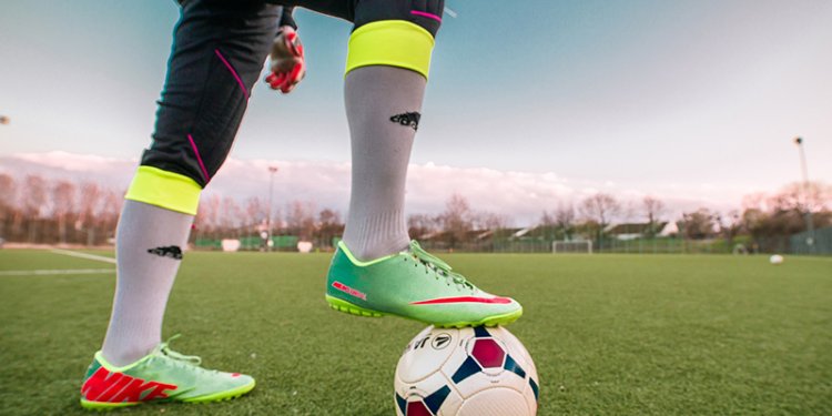 foot with cleats on soccer ball