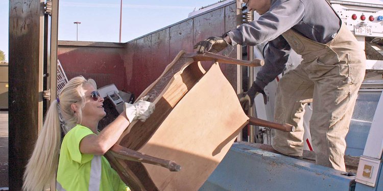 man handing side table to woman attendant