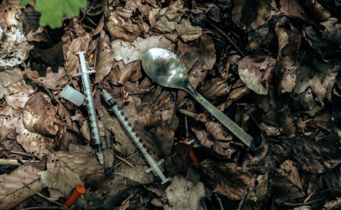 drug paraphernalia on leaves on ground