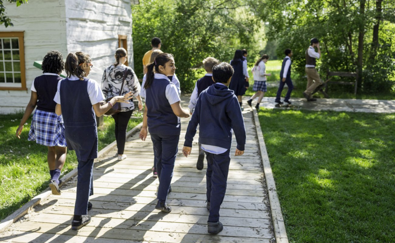 uniformed kids walking down paved path