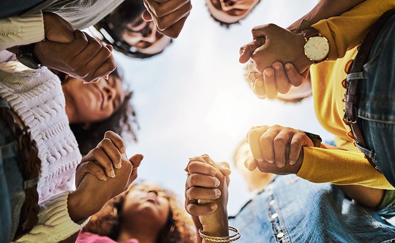 group of friends holding hands in a circle