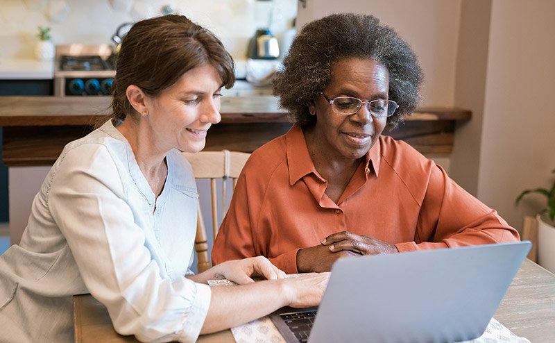 white person assisting senior black person