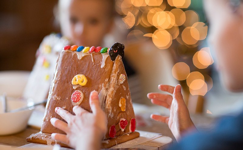 children decorating gingerbread house