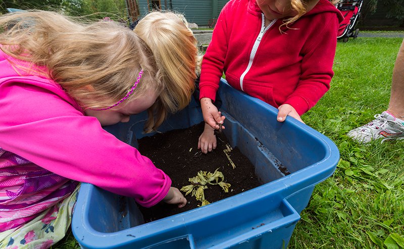 kids playing in dirt in container