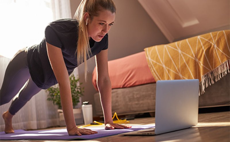 person doing exercise in front of laptop