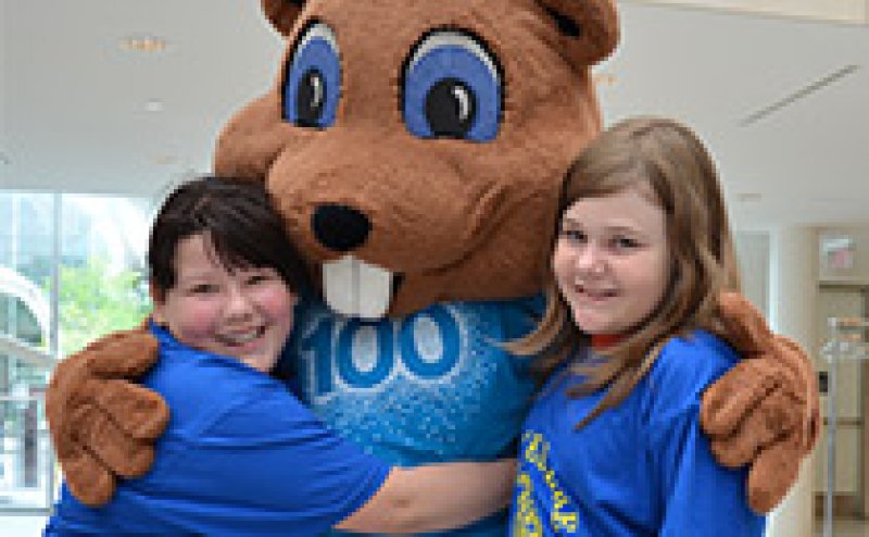 Kids hugging a mascot at City Hall