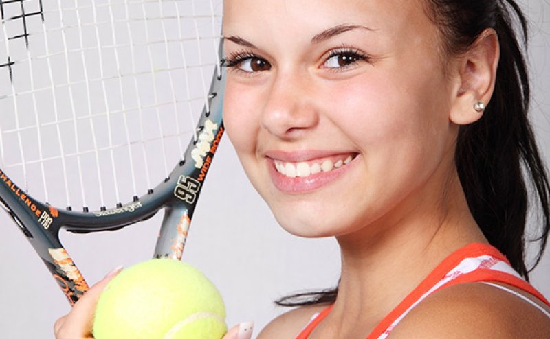 girl with tennis ball and racket