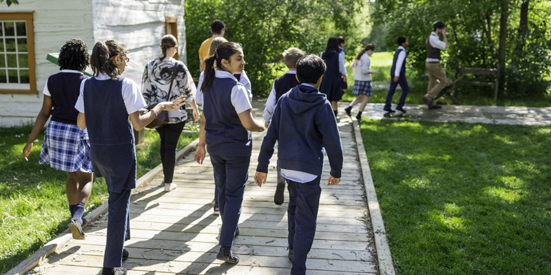 children walking on boardwalk by house