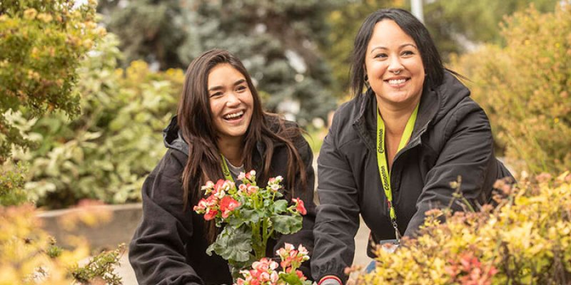 Two smiling volunteers planting