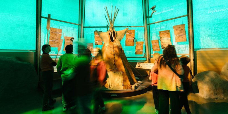 People viewing an Indigenous display at Fort Edmonton Park.