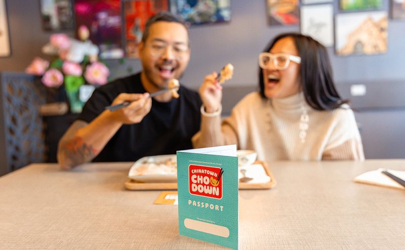 two people eating food with chopsticks